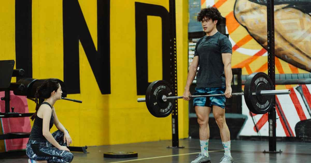 young man performing the barbell deadlift