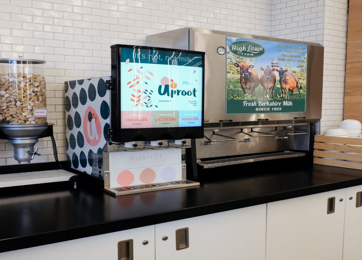 Modern looking vegan milk dispenser next to old fashioned cow's milk dispenser.