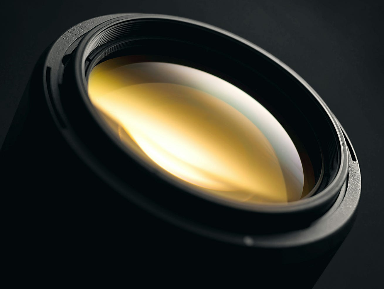 A camera lens with a golden cast on its side looking up