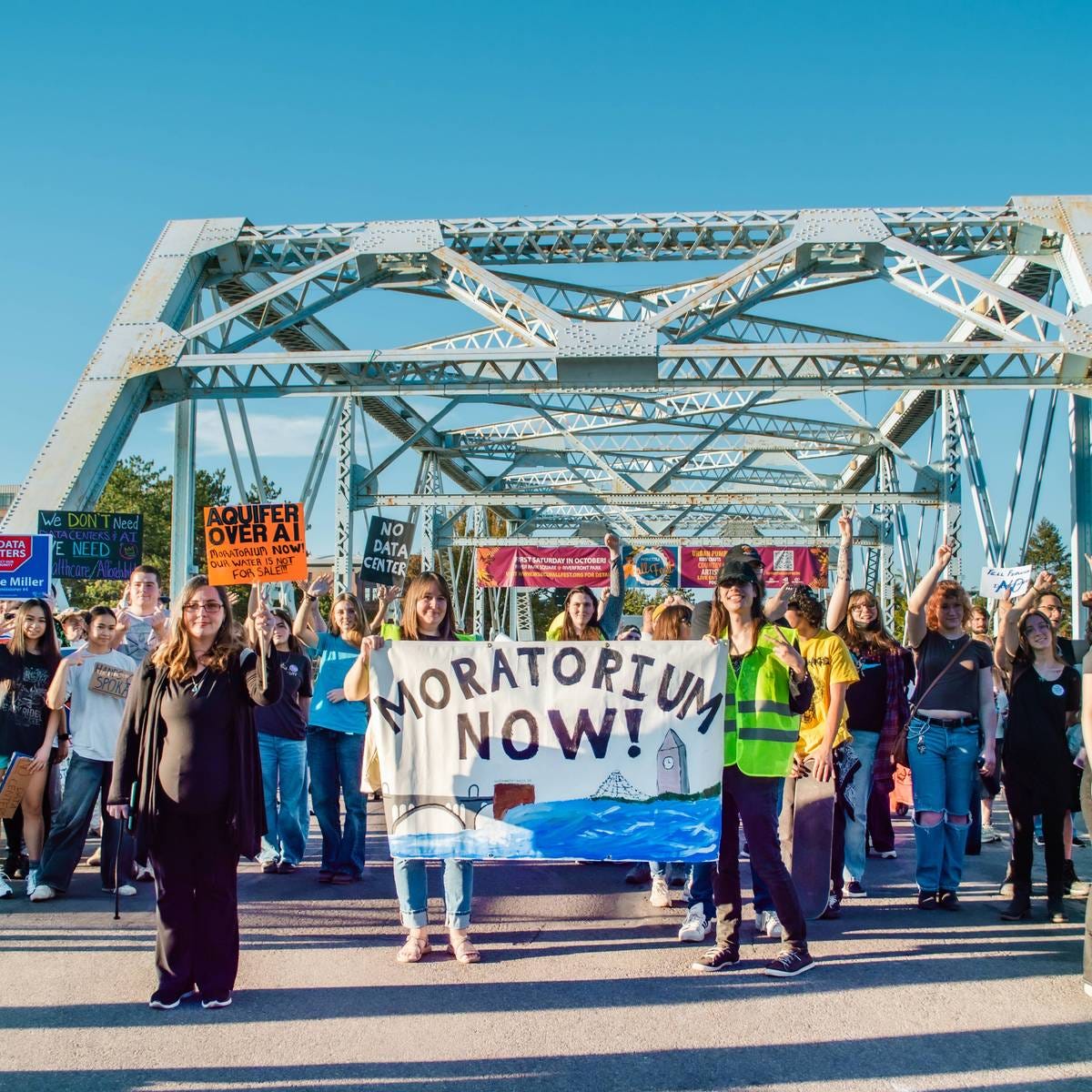 People march on bridge against data centers. People march on bridge against data centers.