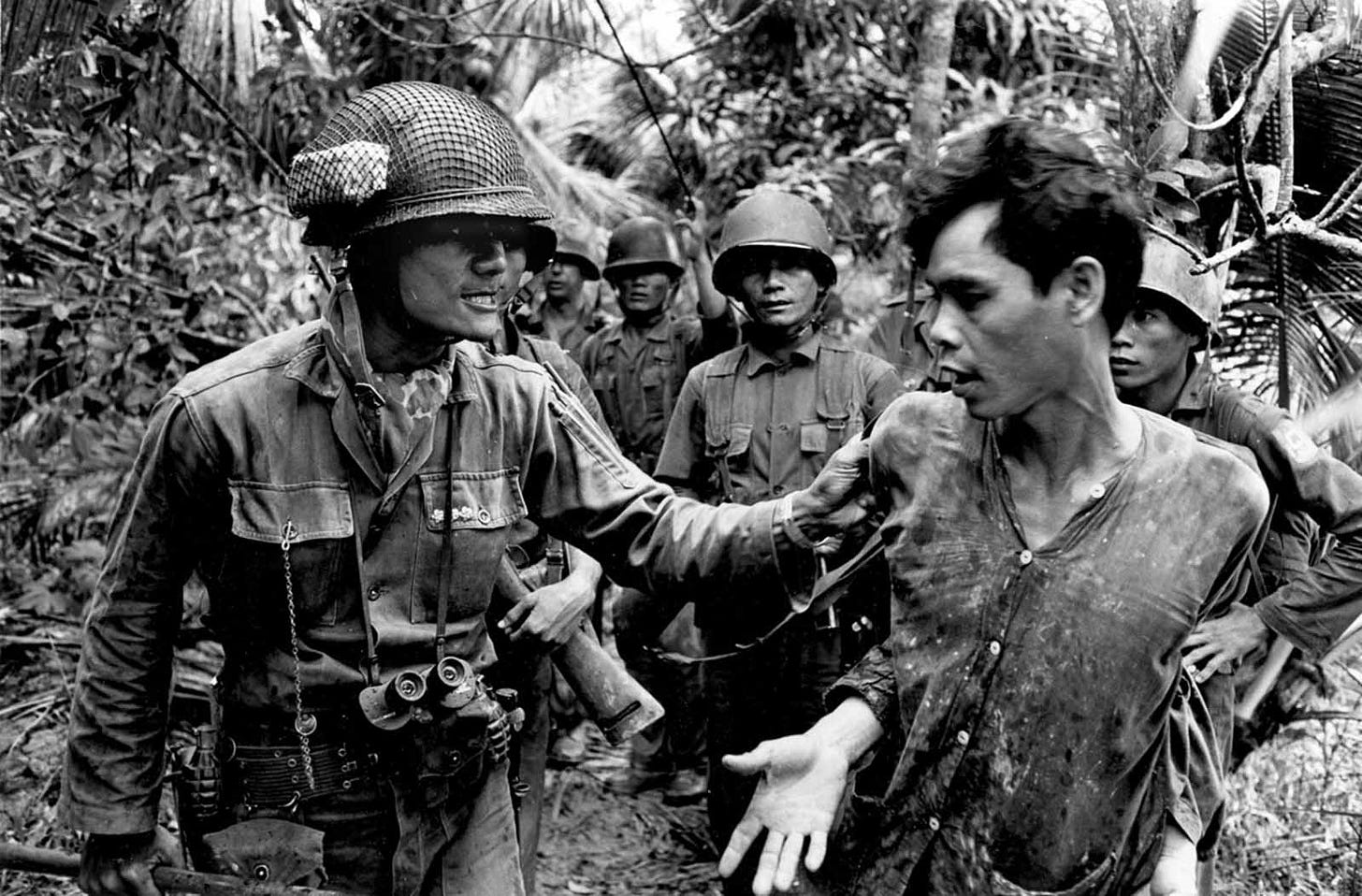 Captain Thach Quyen, a Vietnamese battalion commander, interrogates a captured Viet Cong suspect on Tan Dinh Island, Mekong Delta, in 1965, during a period of escalating conflict. Captain Thach Quyen, a Vietnamese battalion commander, interrogates a captured Viet Cong suspect on Tan Dinh Island, Mekong Delta, in 1965, during a period of escalating conflict.