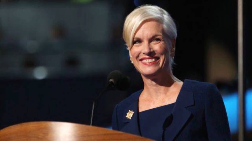 A person smiling at a podium

Description automatically generated