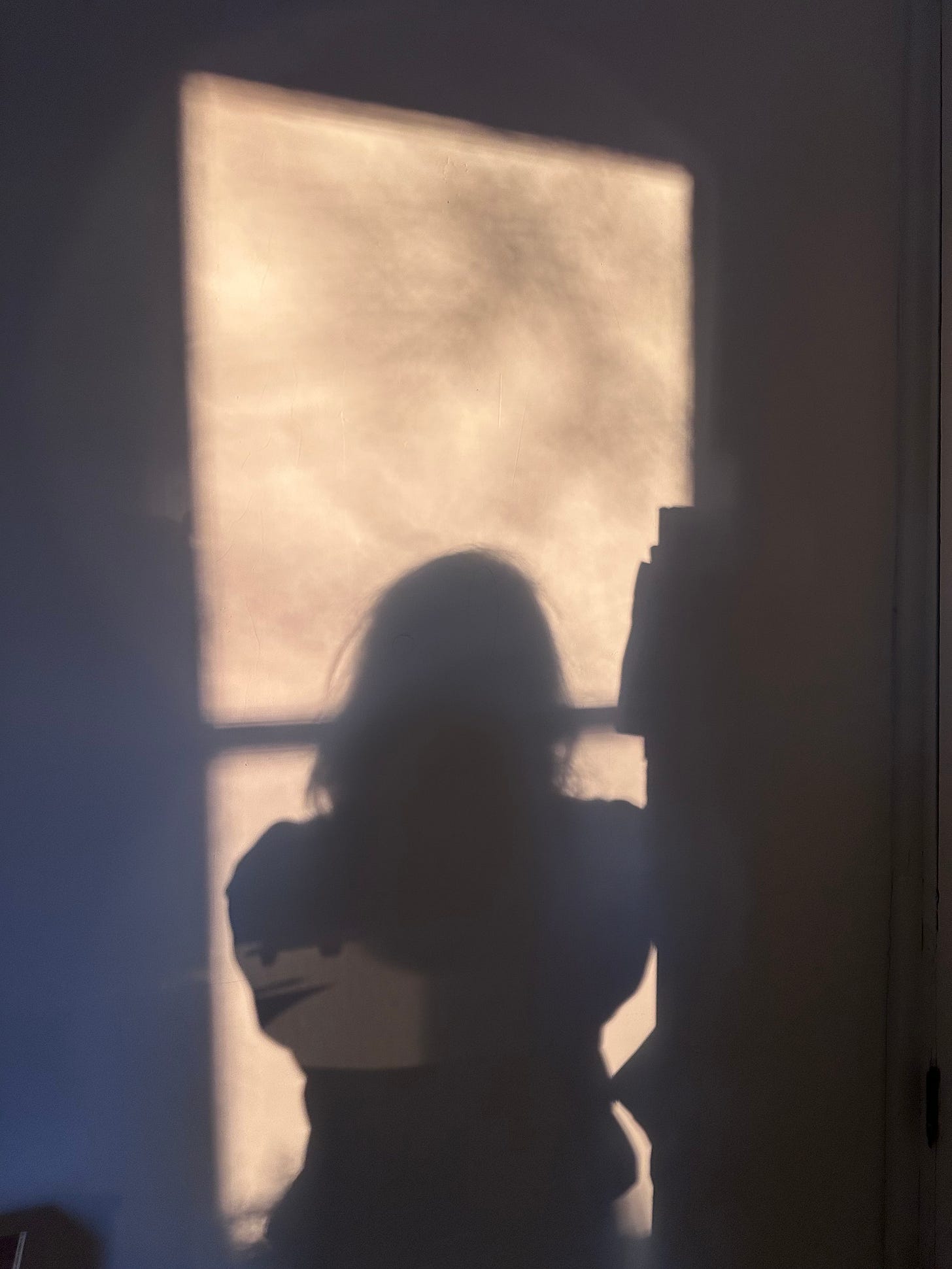 on white wall, skewed rectangle of light through window framing long-haired shadow figure on white wall, skewed rectangle of light through window framing long-haired shadow figure