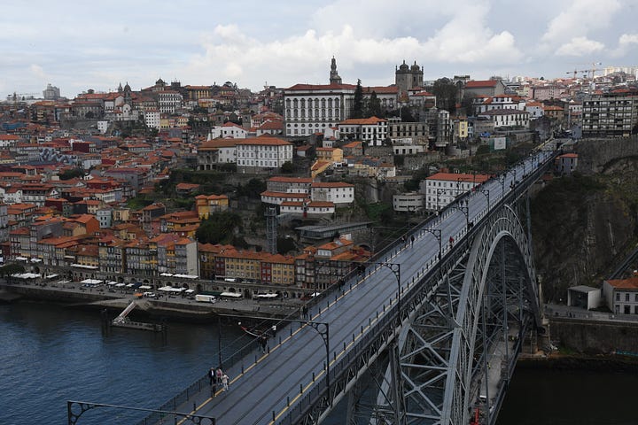 Picture of a bridge in Lisbon, Portugal; Grandma in a yellow dress holding a blanket with Addy; Moose in Grand Tetons National Park and Addy and Lydia at Trout Lake in Yellowstone