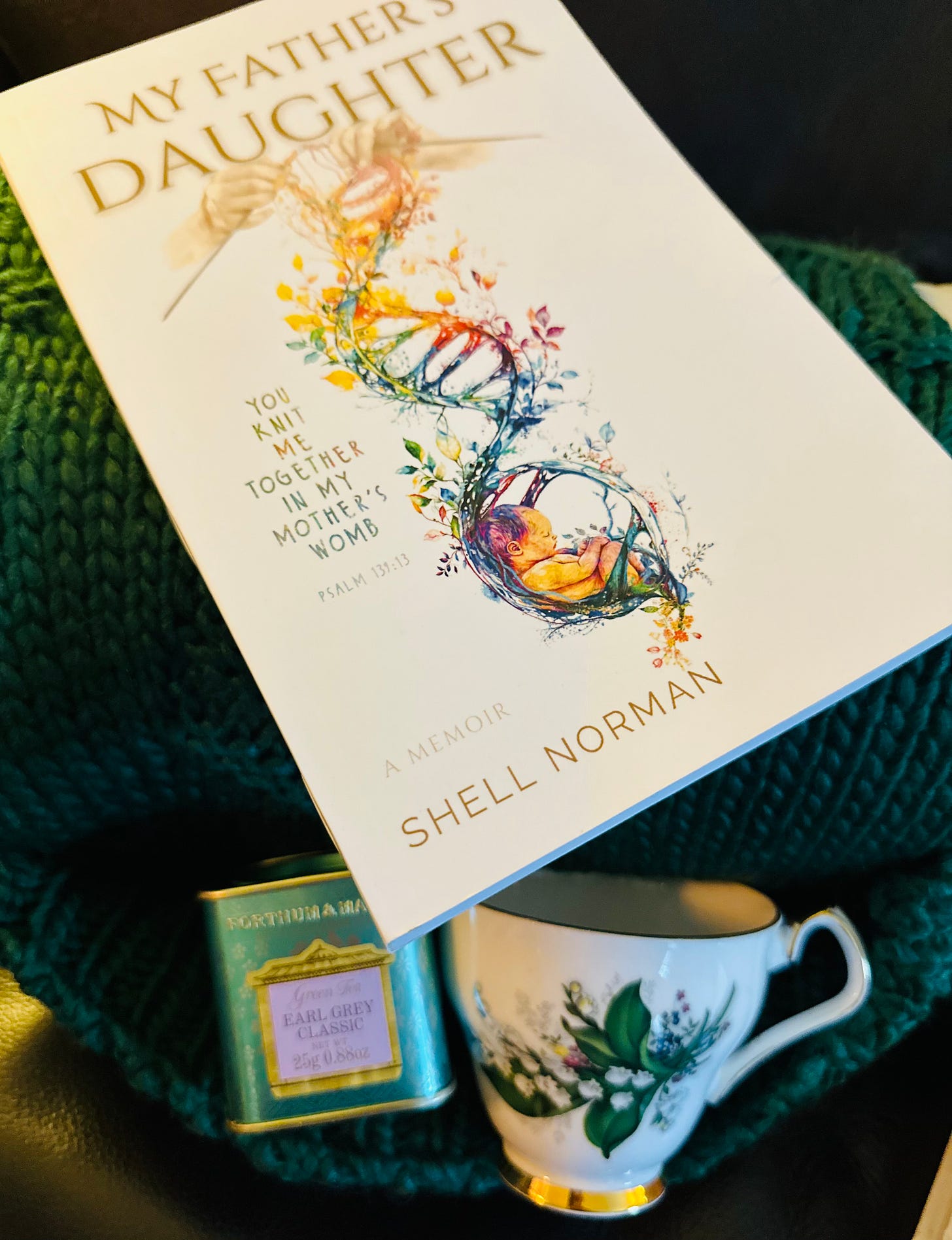 Book with green blanket, tea & teacup