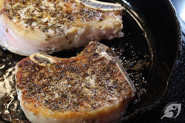 seared pork chops in a cast iron skillet seared pork chops in a cast iron skillet
