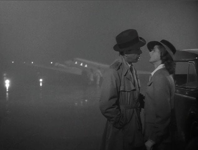 This may contain: two people standing next to each other in front of an airplane