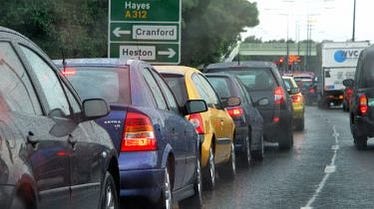 cars queueing on a busy road. there are 7 cars and one white lorry and a sign for Cranford/Heston. cars queueing on a busy road. there are 7 cars and one white lorry and a sign for Cranford/Heston.
