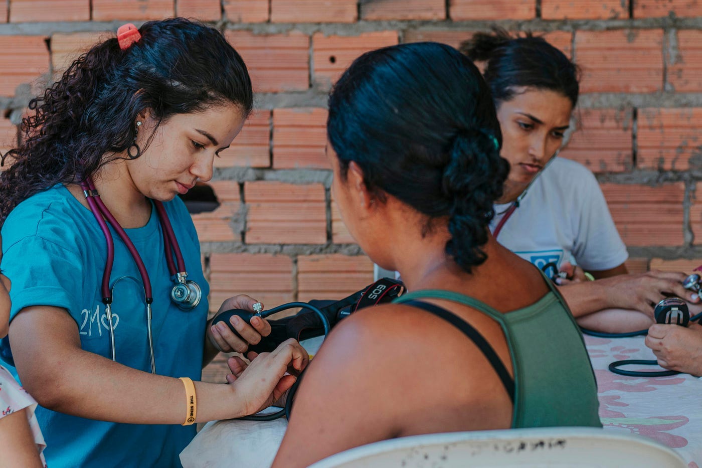 Nurses are seen taking blood pressure readings.
