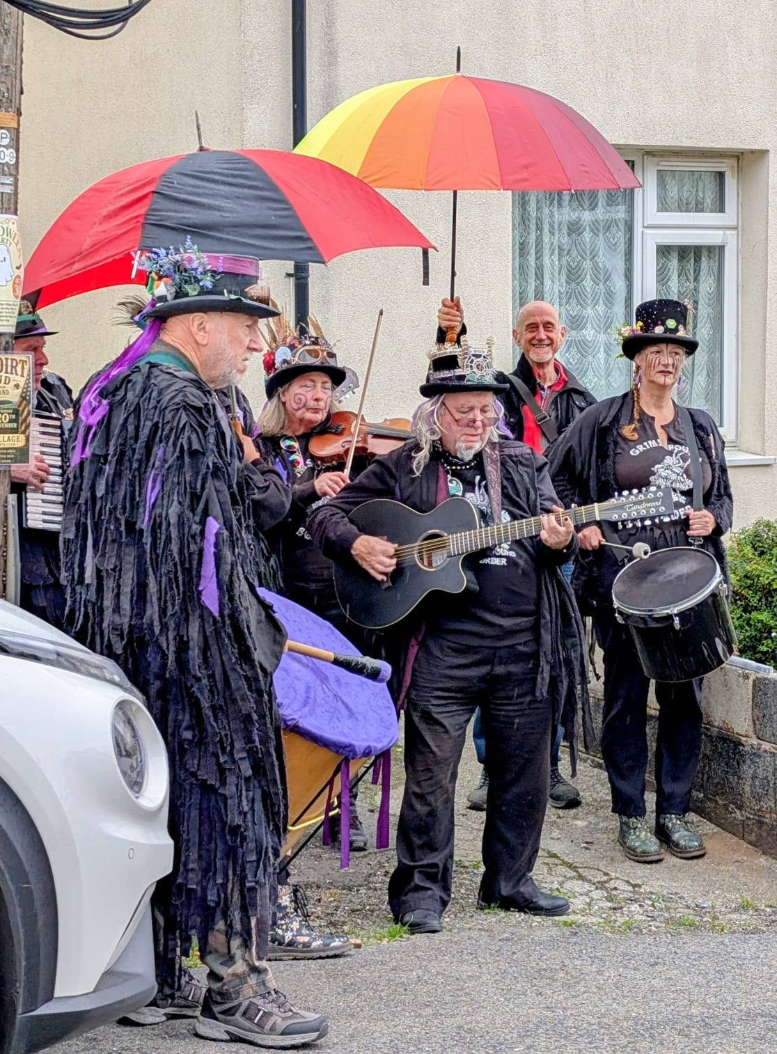 the band for the Morris dancers plus me holding a large rainbow coloured umbrella