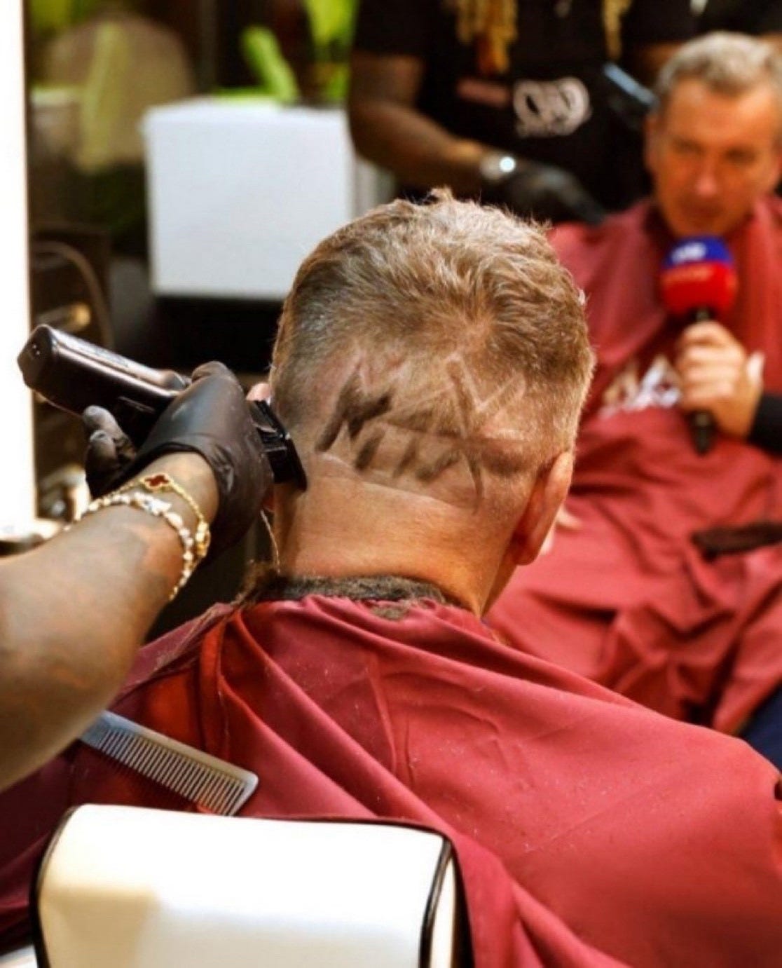 Craig is having the finishing touches put on his new hairdo; it's the M4X logo shaved into his hair on the back of his head. Craig is having the finishing touches put on his new hairdo; it's the M4X logo shaved into his hair on the back of his head.