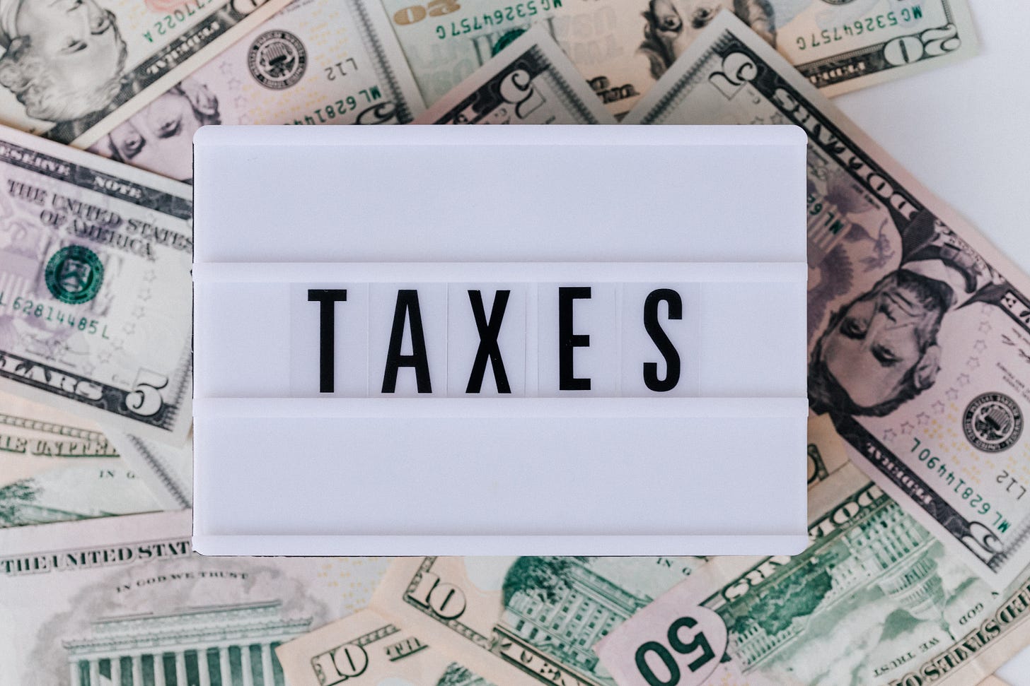 A sign that says "Taxes" on top of US money. 