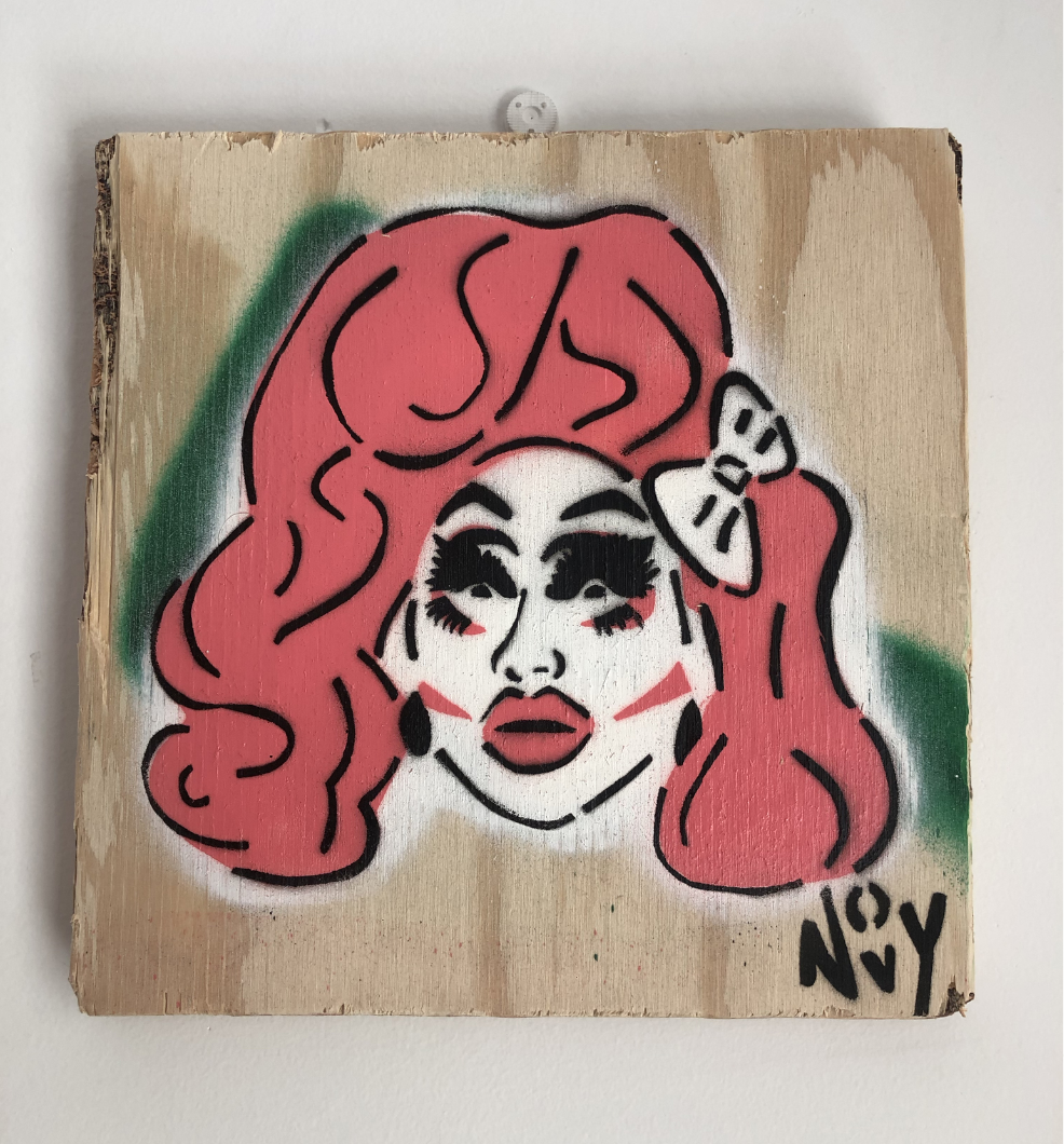 Stylized graffiti portrait of a person with bright pink hair and a bow on wooden board. Black and red detailing, green accents. Bold and vibrant tone. The portrait is of Trixie Mattel, a famous drag queen. She has big pink hair with a white bow on the side. She has very stylized eyelashes and eyeshadow, and she has pink lines on her cheeks, and big red lips. Jeremy's signature/tag, Novy, is in the bottom right corner in black. Stylized graffiti portrait of a person with bright pink hair and a bow on wooden board. Black and red detailing, green accents. Bold and vibrant tone. The portrait is of Trixie Mattel, a famous drag queen. She has big pink hair with a white bow on the side. She has very stylized eyelashes and eyeshadow, and she has pink lines on her cheeks, and big red lips. Jeremy's signature/tag, Novy, is in the bottom right corner in black.