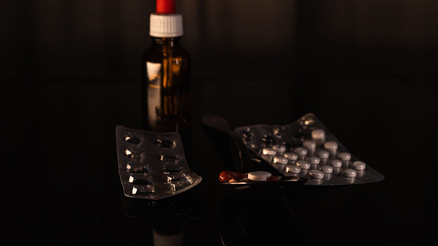 Photo by Bastian Riccardi on Pexels A collection of pharmaceuticals including pills and a bottle on a dark surface. (stock photo)