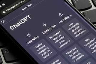 A photo of a phone showing ChatGPT on the screen. A photo of a phone showing ChatGPT on the screen.