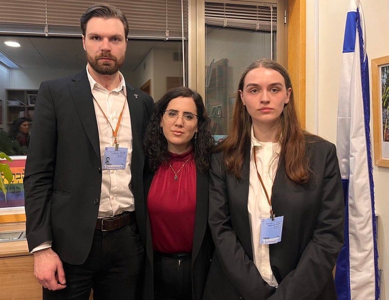 Three people in suits pose for a photo