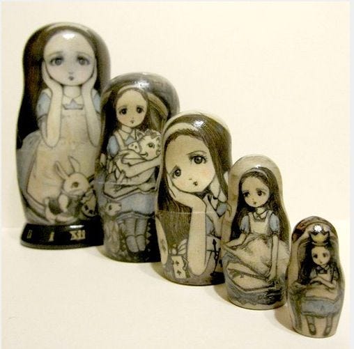 This may contain: a group of nesting dolls sitting next to each other on a white surface with one holding a baby doll