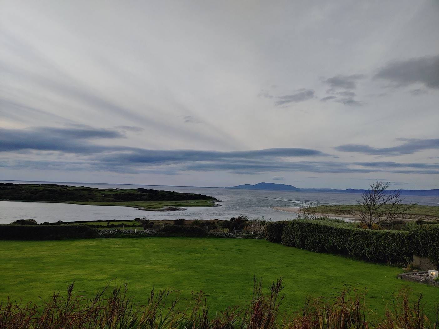 A landscape with a body of water and grass

AI-generated content may be incorrect.