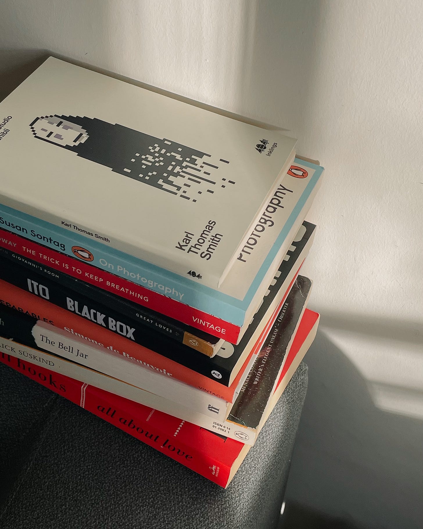 A stack of nine books from my winter reading list, neatly arranged.