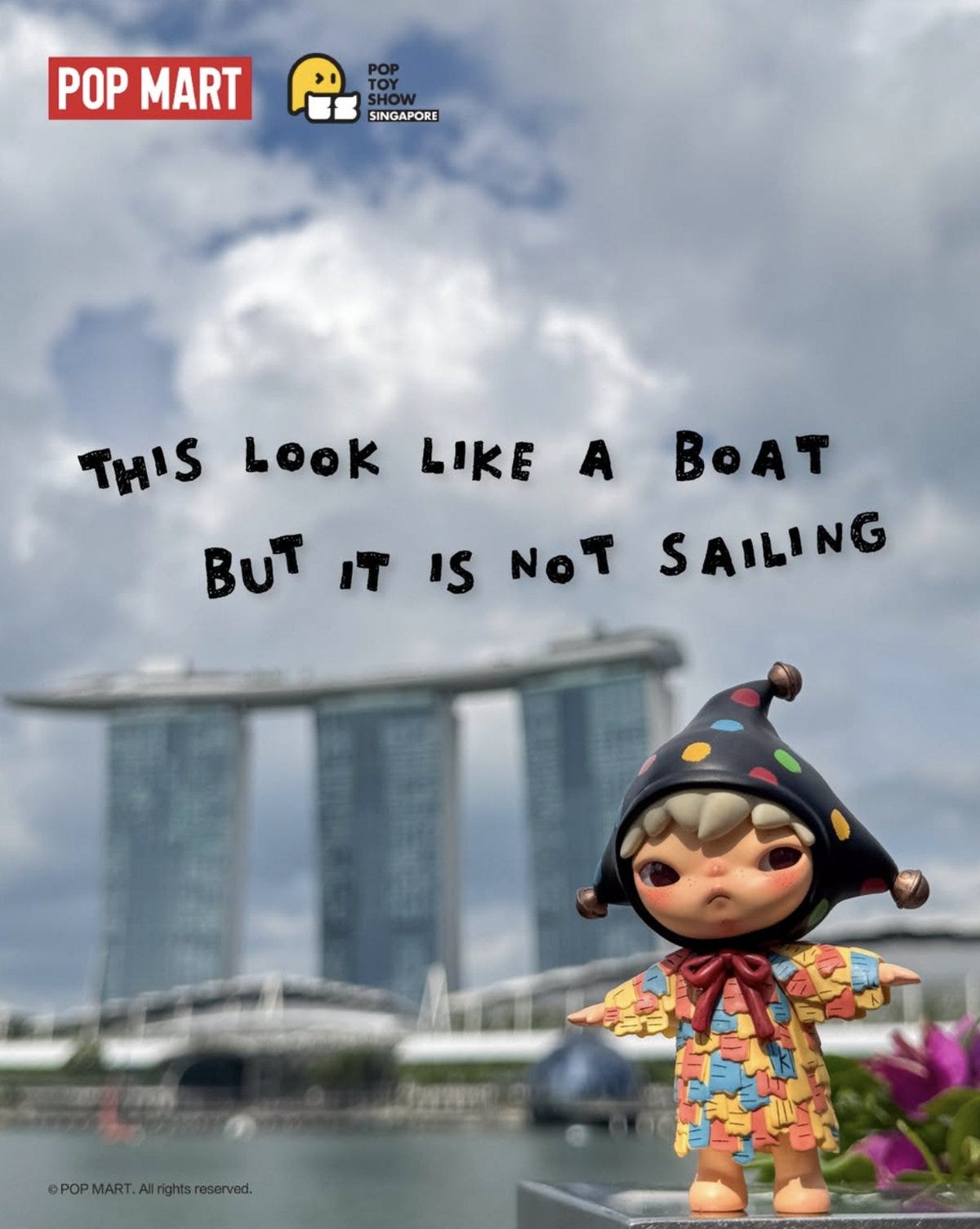 Hirono figurine in front of Marina Bay Sands skyline with playful caption “This look like a boat but it is not sailing.”
