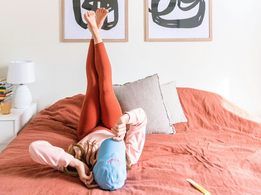 a woman laying on top of a bed in a bedroom