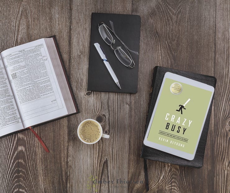book cover crazy busy by kevin deyoung on desk with notebook and cup of coffee