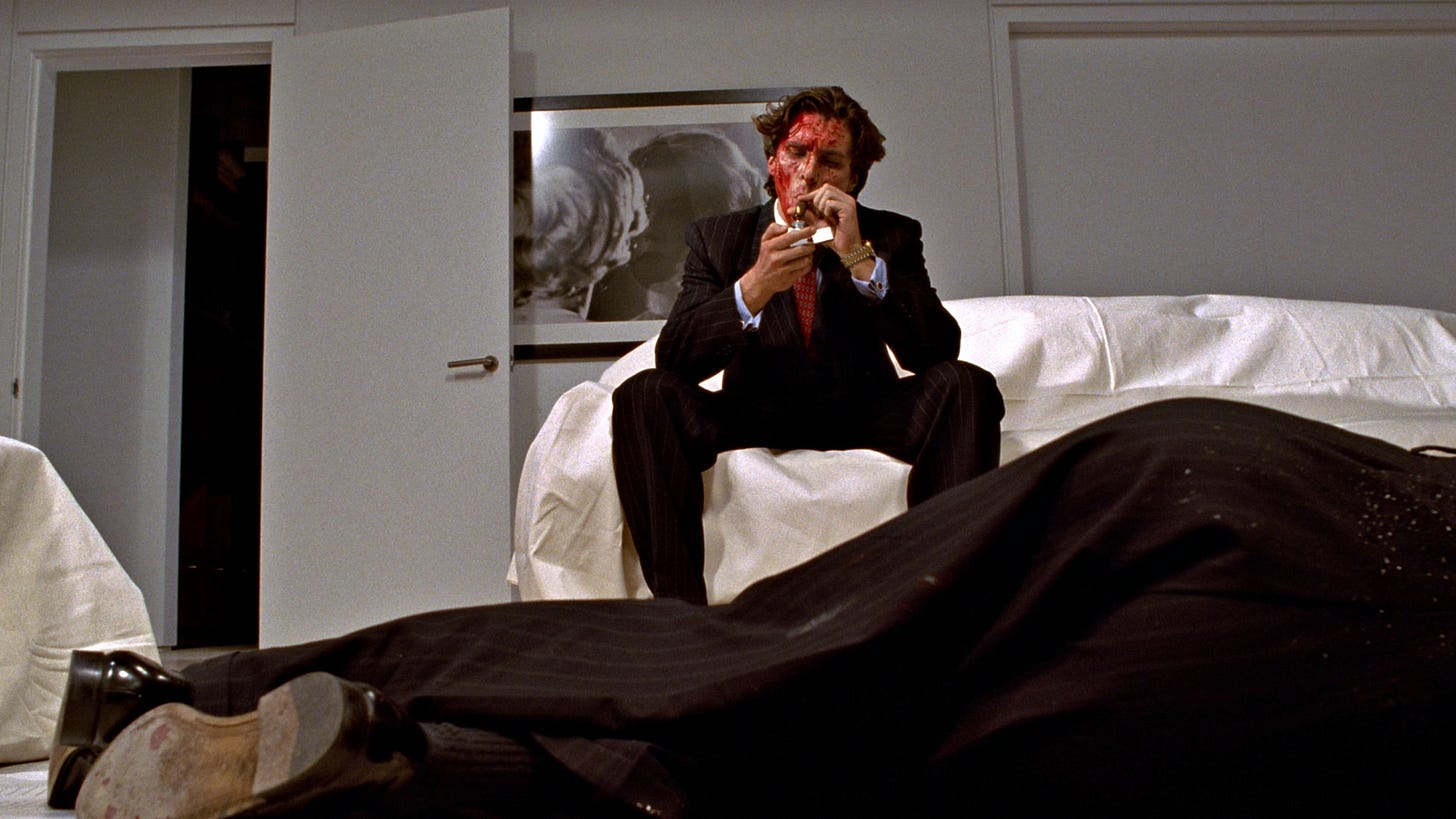American Psycho | Still features Christian Bale as Patrick Bateman with blood over his face observing a dead body.