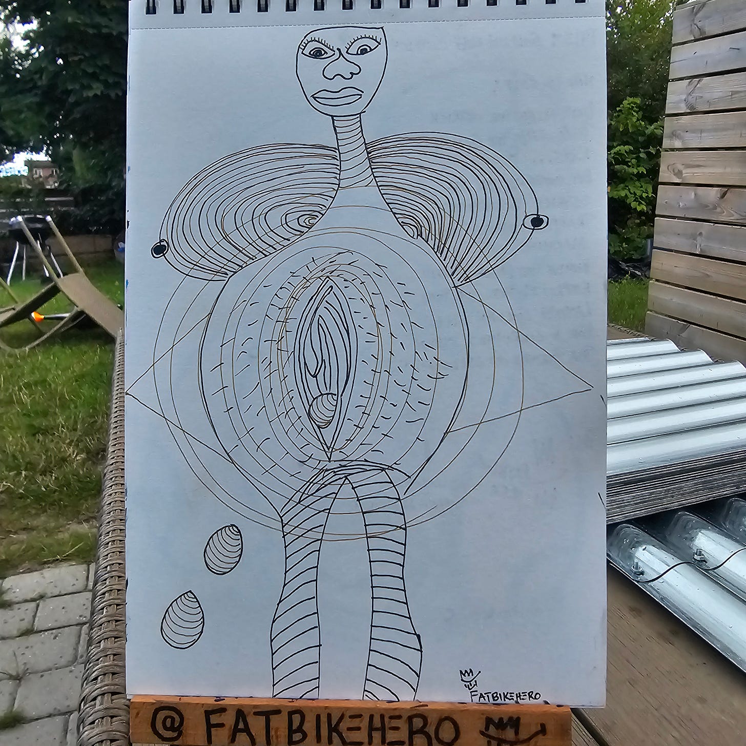 Alt Text: A pen and ink drawing by FatbikeHero titled 'Golden Egg Ostrich'. A surreal, stylized figure with a human face and elongated neck stands with a large, concentric oval body containing a vertical, eye-like shape. The figure has striped legs and drops two patterned eggs. The style is raw, geometric, and surrealist. Alt Text: A pen and ink drawing by FatbikeHero titled 'Golden Egg Ostrich'. A surreal, stylized figure with a human face and elongated neck stands with a large, concentric oval body containing a vertical, eye-like shape. The figure has striped legs and drops two patterned eggs. The style is raw, geometric, and surrealist.