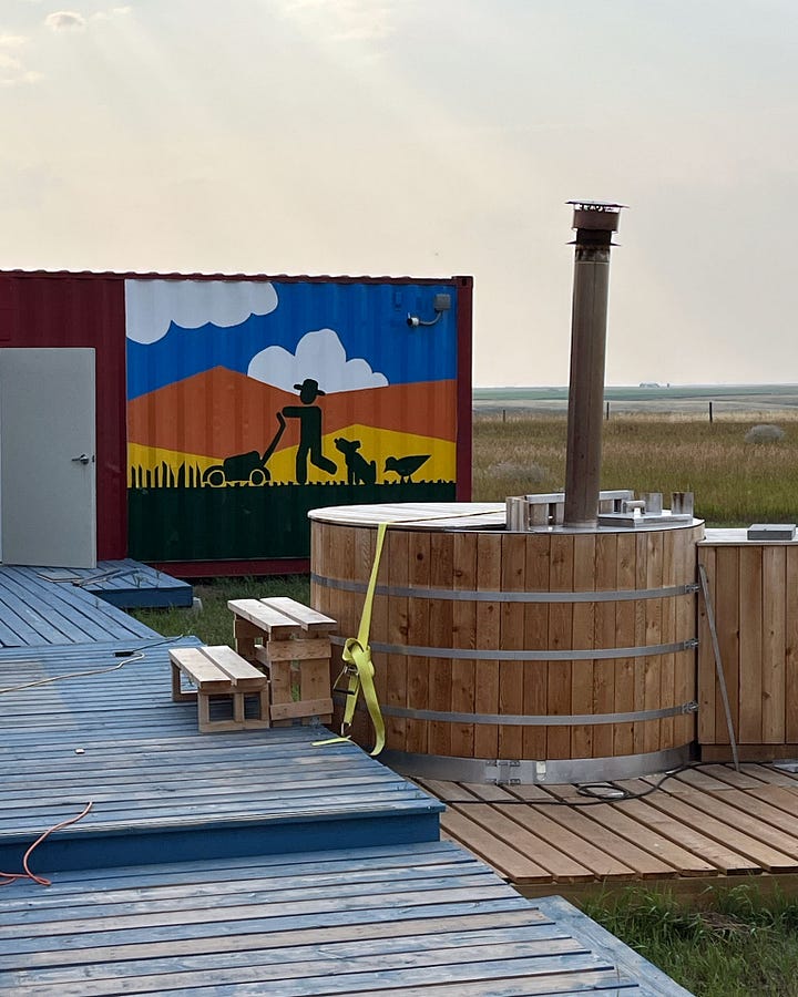 Photo gallery of process shots of the painting of The Lawn Mower Mural on the side of a shipping container cabin.