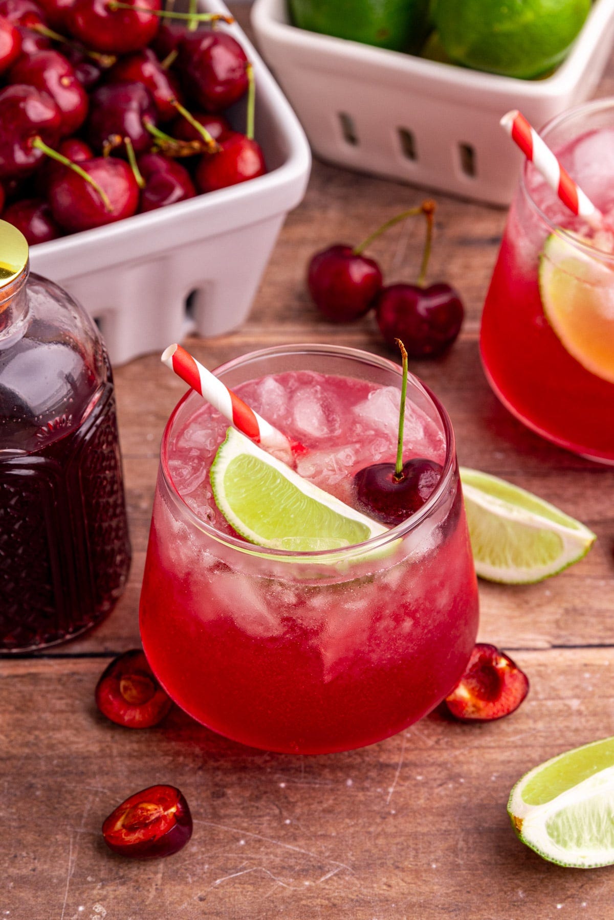 A cherry mocktail, garnished with a lime wedge and a cherry.
