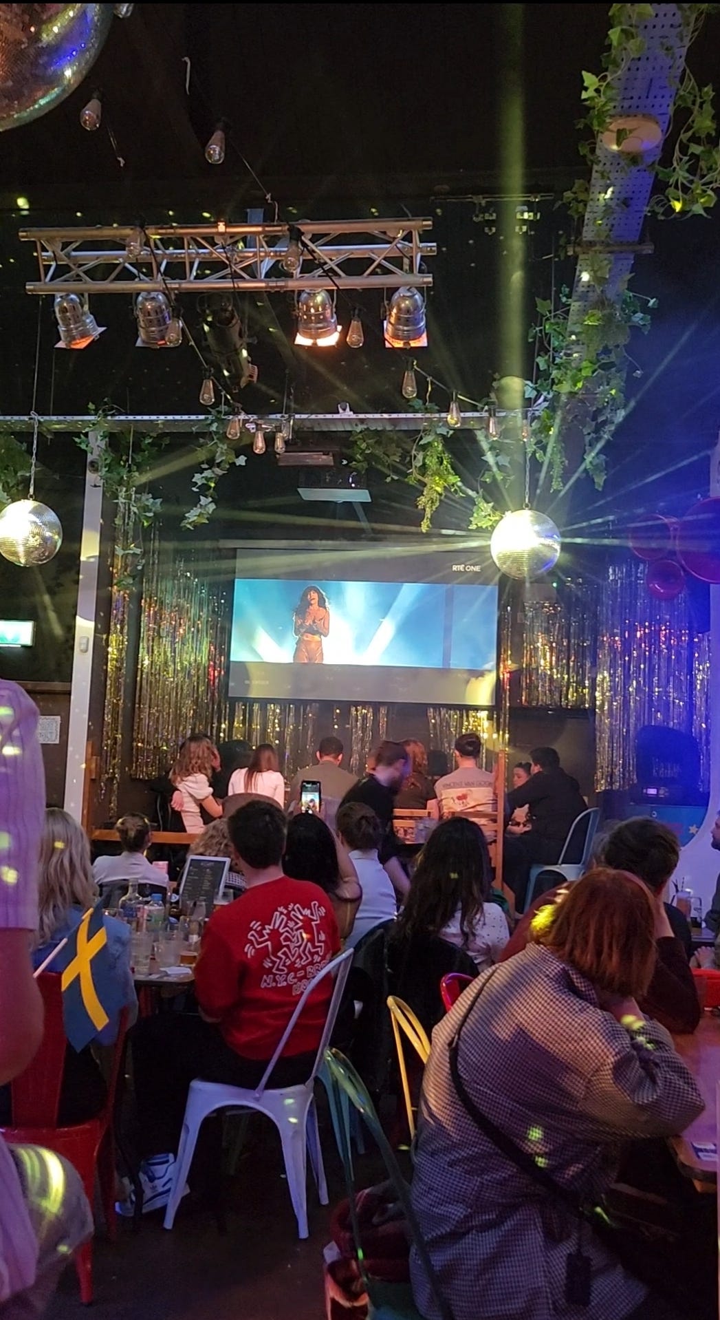 Taken on Eurovision night, a big screen plays Loreen as disco balls catch the light and a tiny Swedish flag is held by a fan