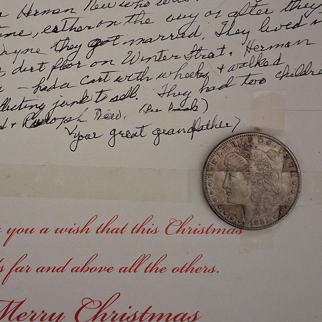 The inside of a Christmas card with handwritten note at the top and a silver dollar taped to the center right.