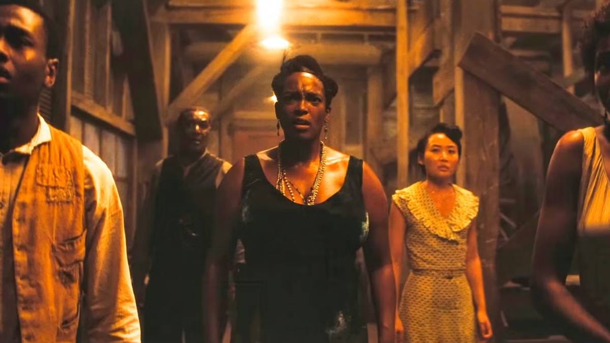 Annie (Wunmi Mosaku) and Grace (Li Jun Li) stand in a group and look fearful in Sinners.