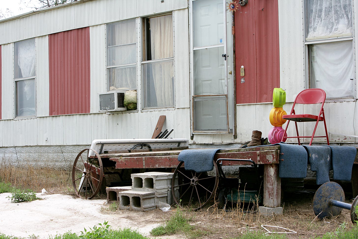 run down trailer with wagon wheels and plastic fans