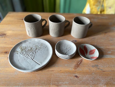 unfired clay beakers, tray, mugs and plates