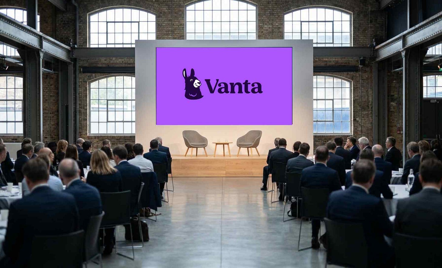 A wide editorial photograph of a London conference venue interior at VantaCon UK 2026, illustrating the corporate-trust analytical setting at the centre of The Control Layer's Trust Is the Growth Engine series.