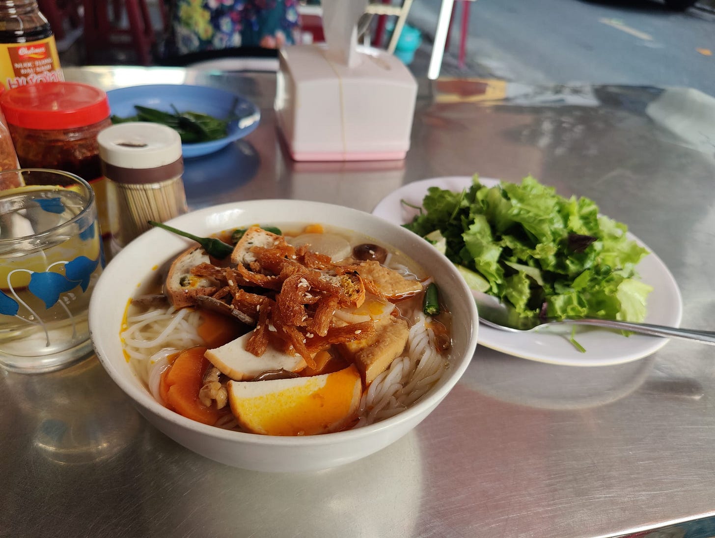 a bowl of hot noodle soup and greens