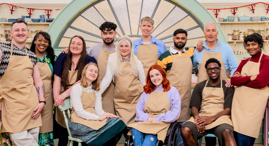 A group of people wearing brown aprons stood together in front of a glass window A group of people wearing brown aprons stood together in front of a glass window