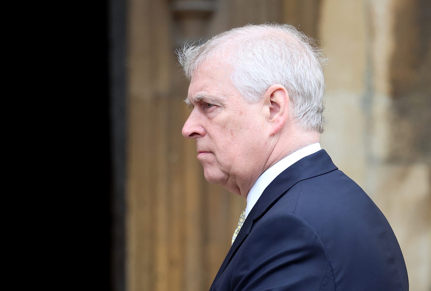 Prince Andrew frowning, wearing a suit