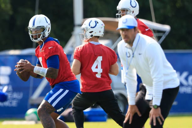 Anthony Richardson of the Indianapolis Colts throws a pass as head coach Shane Steichen looks on during training camp at Grand Park Sports Campus on...