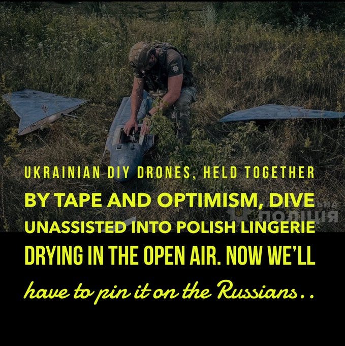 A person in military attire working on a drone in a grassy outdoor setting. The drone has a triangular shape and appears held together with tape. Yellow text overlay reads "UKRAINIAN DIY DRONES: HELD TOGETHER BY TAPE AND OPTIMISM, UNASSISTED INTO POLISH LINGERIE DRYING IN THE OPEN AIR. NOW WE\'LL HAVE TO PIN IT ON THE RUSSIANS . . ."