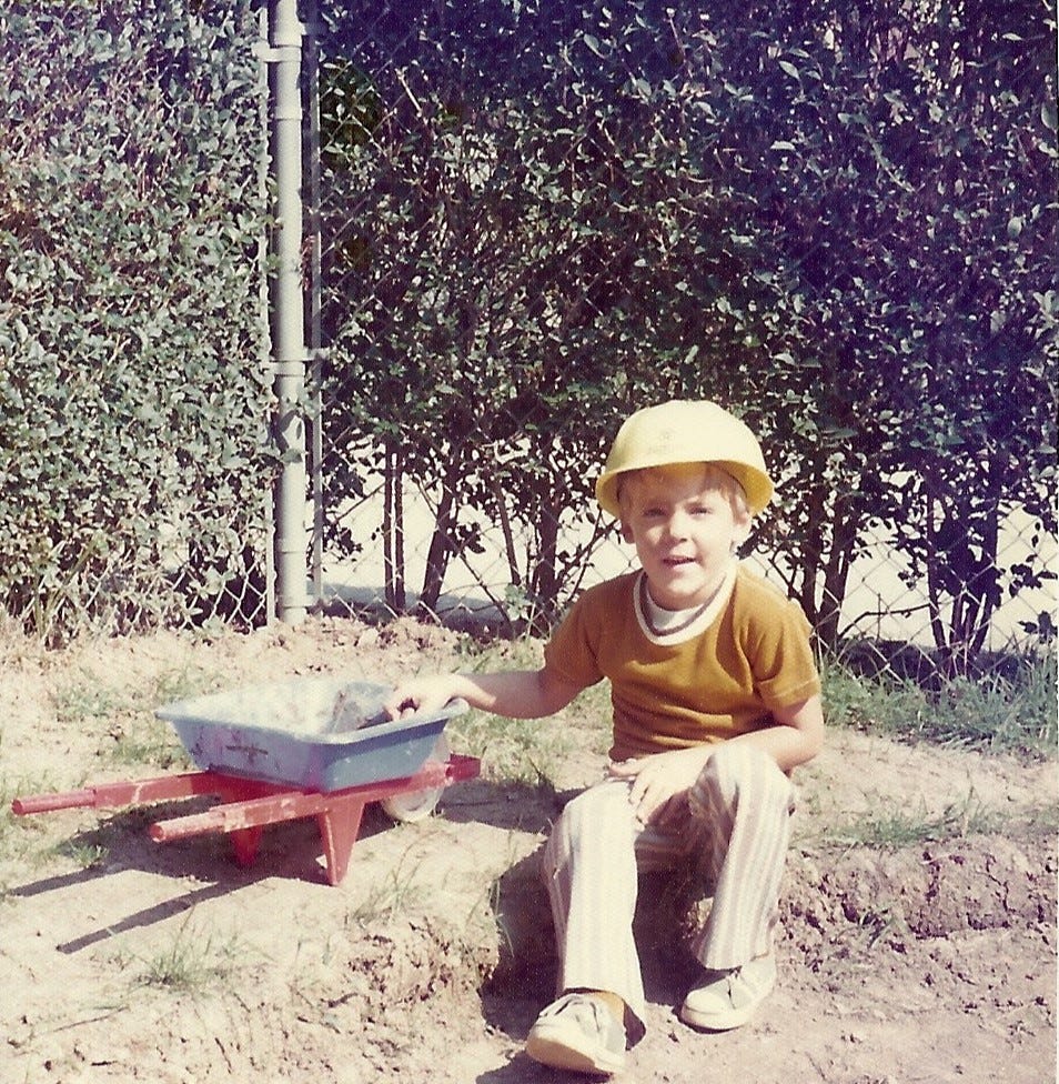 4-year-old boy in a construction hat is ready to tackle his own mini-construction project in his backyard