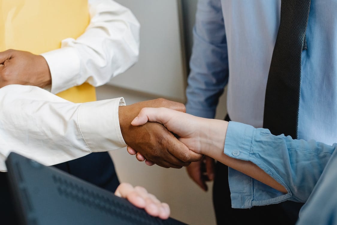Gratis Compañeros Multirraciales Estrecharme La Mano En El Trabajo Foto de stock