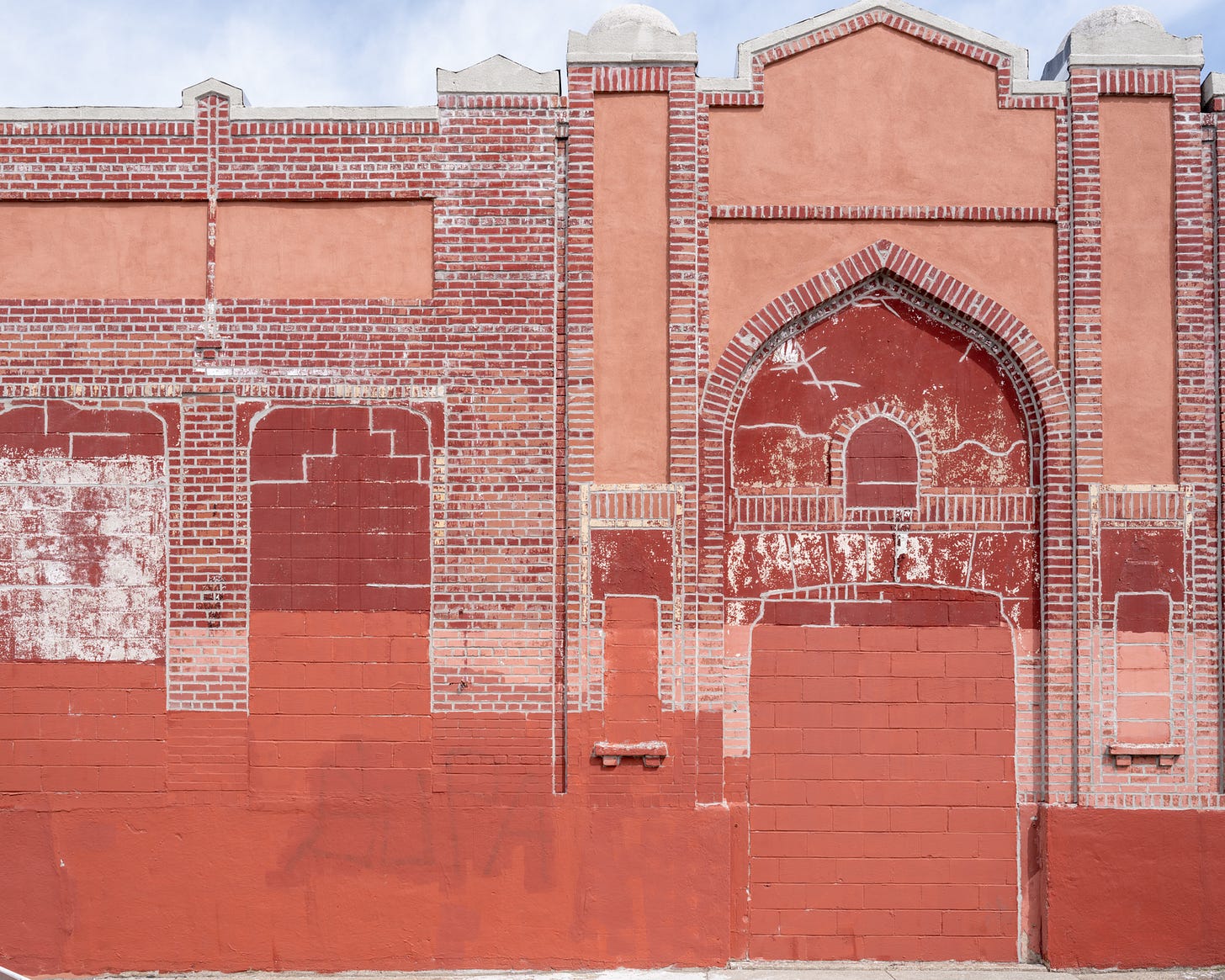 Red painted, moorish looking wall with bricks