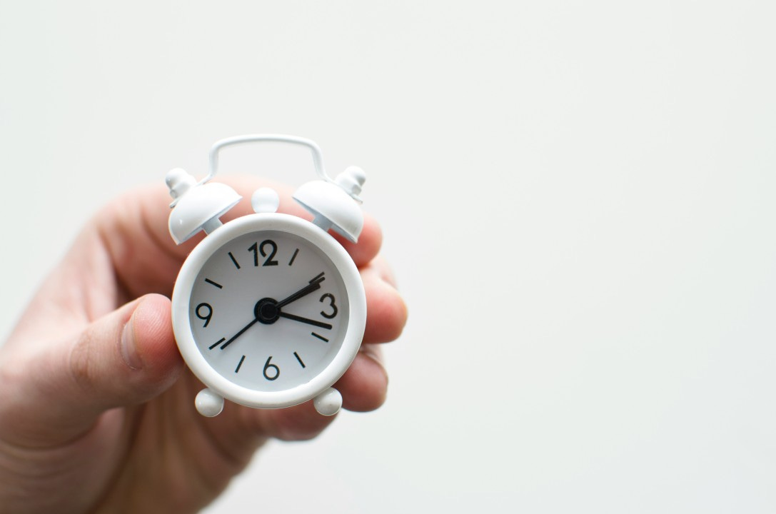 Hand holding a mini white clock