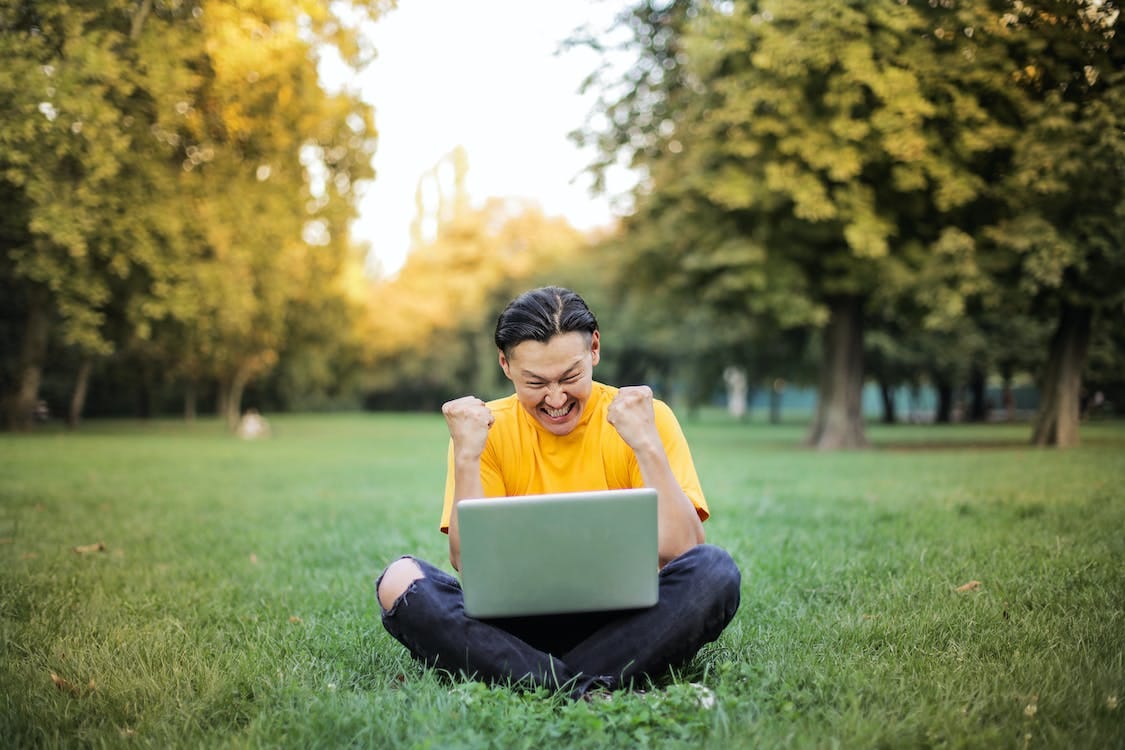 Free Man Sitting on a Green Grass Field Stock Photo Free Man Sitting on a Green Grass Field Stock Photo