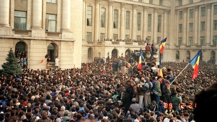 Protesters in Bucharest wave Romanian flags as they stage an anti-communist demonstration at Republic Square, 21 December 1989 Protesters in Bucharest wave Romanian flags as they stage an anti-communist demonstration at Republic Square, 21 December 1989