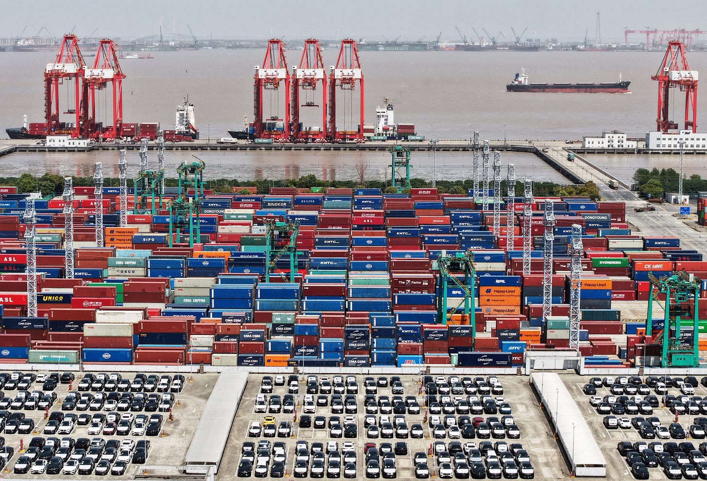 Drone view shows electric vehicles (EV) for export and containers sitting at a port in Shanghai