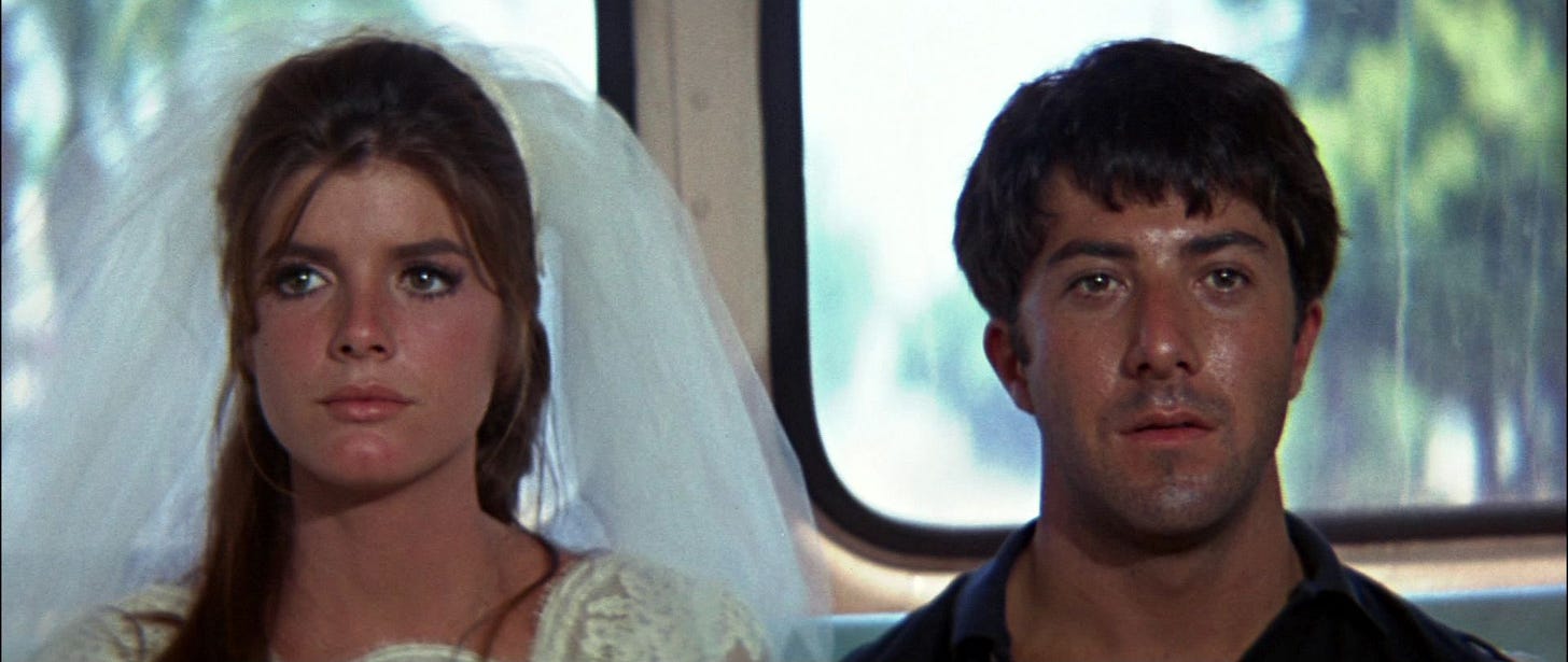 A still from the movie "The Graduate," featuring a runaway bride and her admirer, riding into the future at the back of a bus.