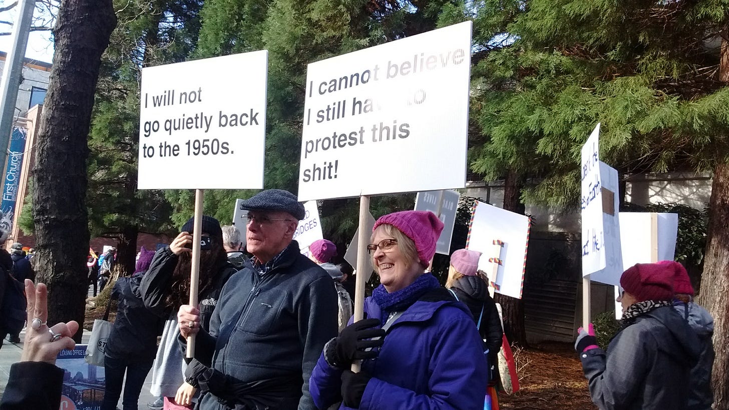Older man with sign saying "I will not go quietly back to the 1950s."